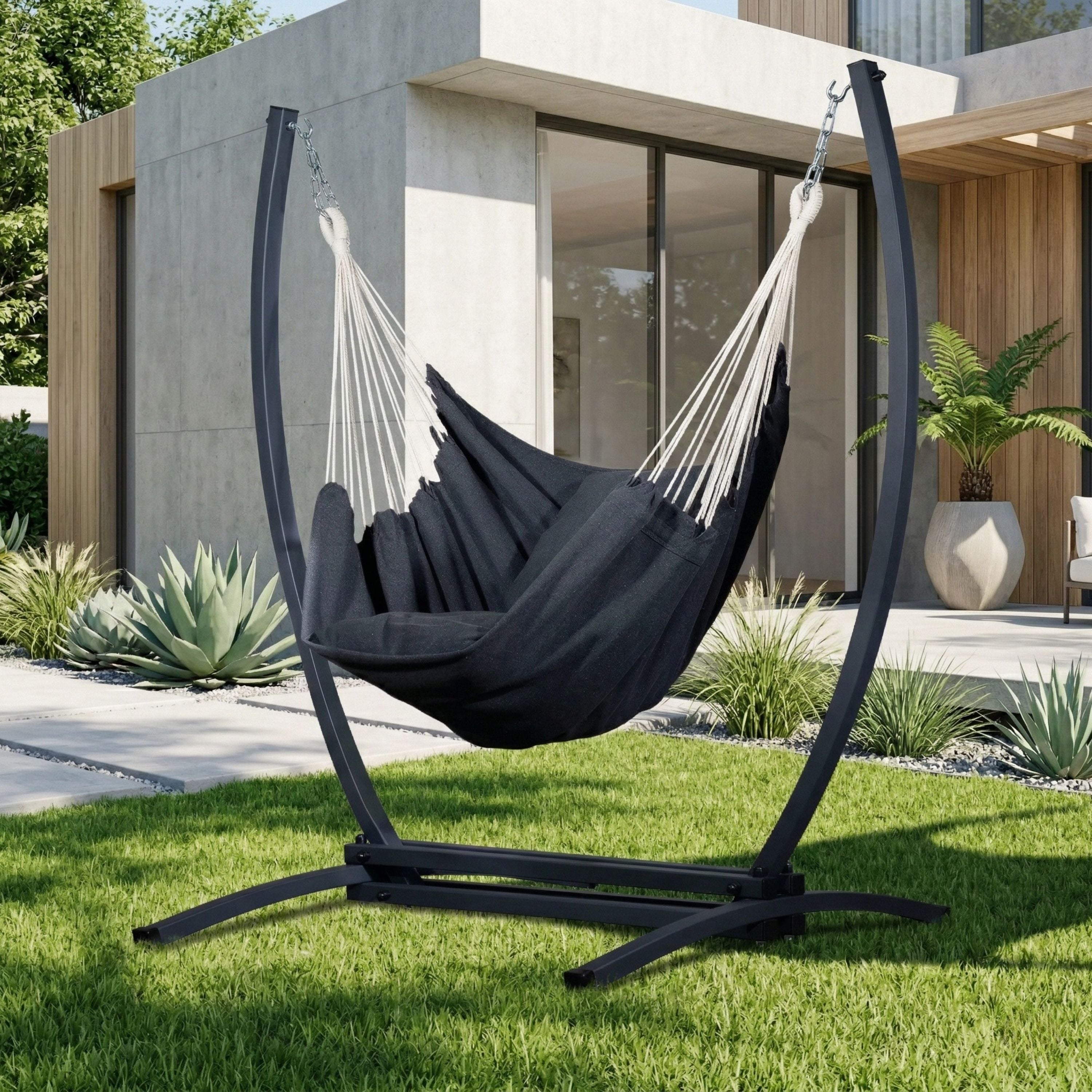 Fauteuil suspendu gris de hamacio sur un jardin de maison.