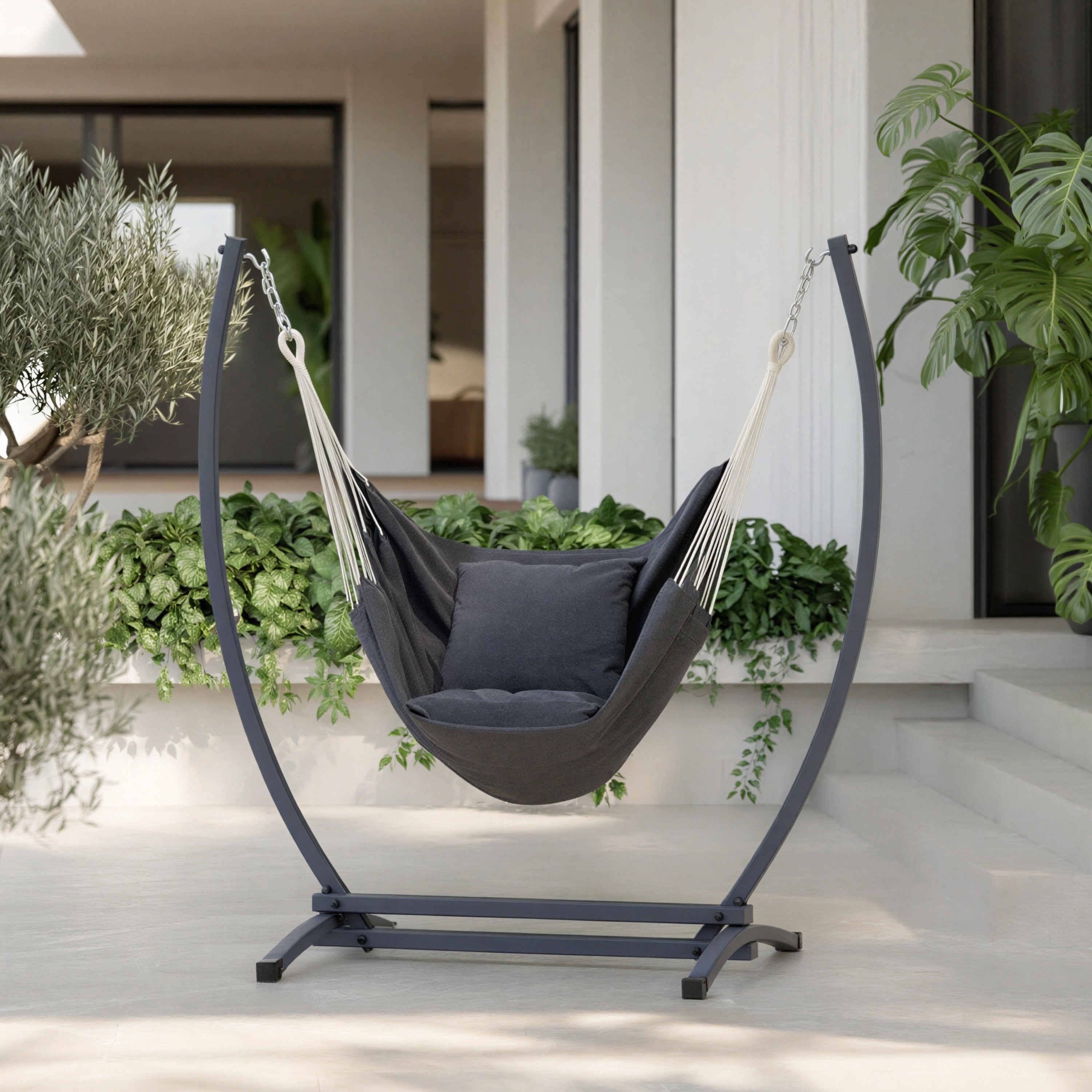 Fauteuil suspendu gris de hamacio sur une terrasse de maison, possible en intérieur et extérieur