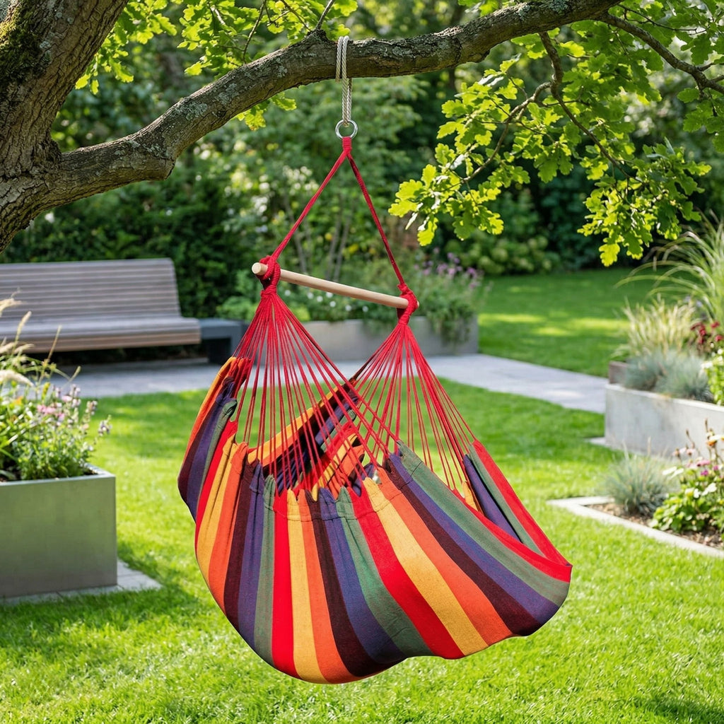 Fauteuil suspendu rouge, jaune et violet, modèle Horizonte de chez Hamacio dans un jardin moderne et lumineux 