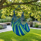 Fauteuil suspendu vert Horizonte de chez Hamacio dans un jardin moderne et ensoleillé 