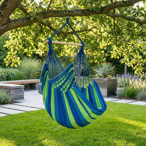 Fauteuil suspendu vert Horizonte de chez Hamacio dans un jardin moderne et ensoleillé 