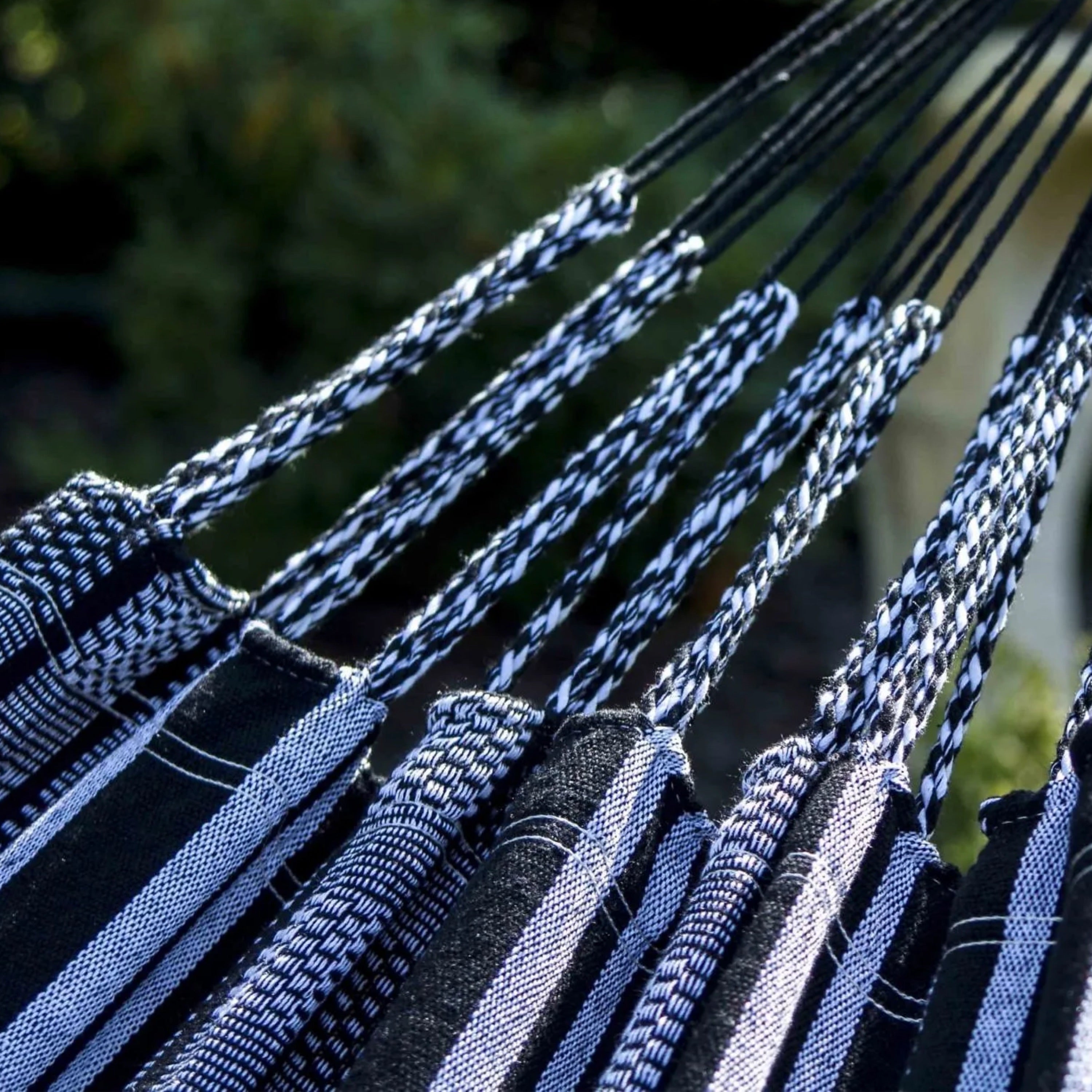 zoom sur les cordes et le tissu du hamac noir colombiano dans un jardin