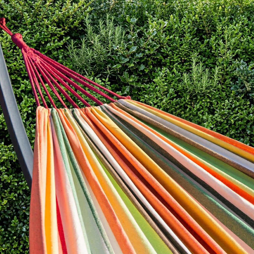 Hamac orange, modèle Horizonte de Hamacio dans un jardin lumineux.