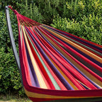 Hamac rouge horizonte dans un jardin lumineux.