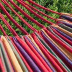 Hamac rouge horizonte avec un zoom sur la matière et les cordes dans un jardin de maison 
